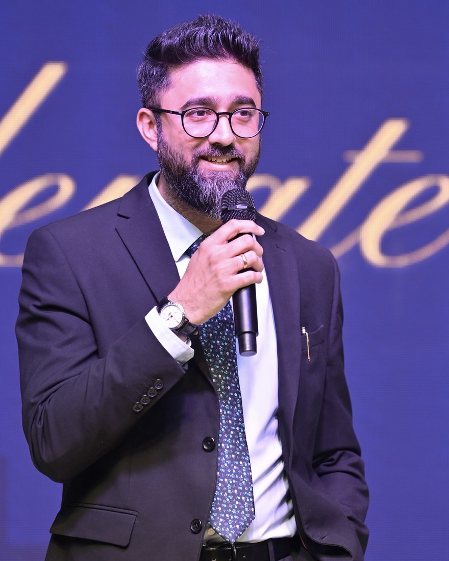 Hitesh Parmar speaking on stage with a microphone